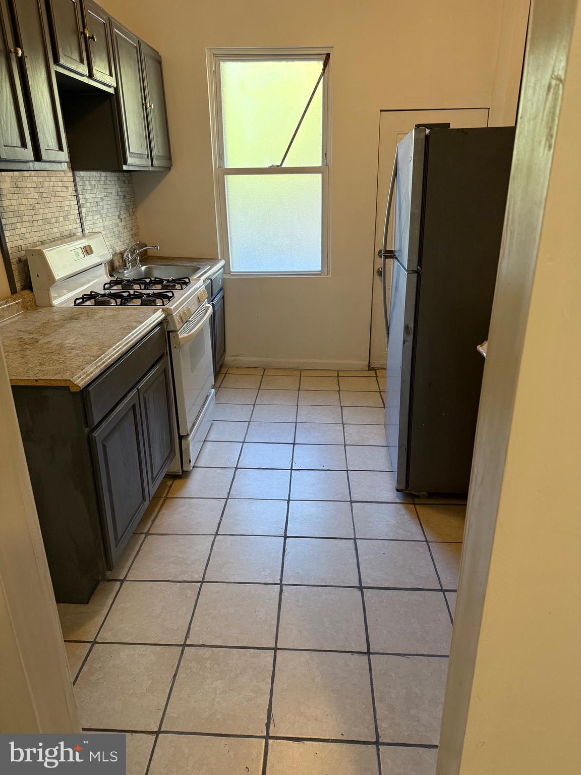 2856 Tulip Street Philadelphia, PA 19134 - Photo 5 of 13 a kitchen with a sink a refrigerator and a stove
