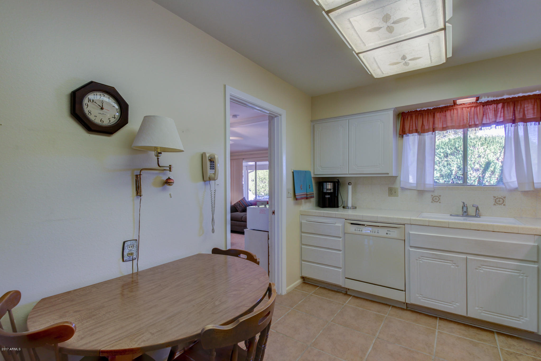 10008 West Riviera Drive Sun City, AZ 85351 - Photo 15 of 26 a kitchen with a table chairs and white cabinets