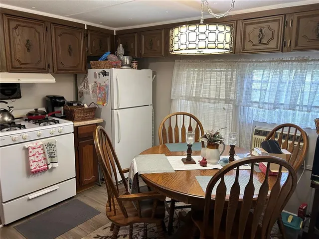 a kitchen with a dining table chairs refrigerator and cabinets