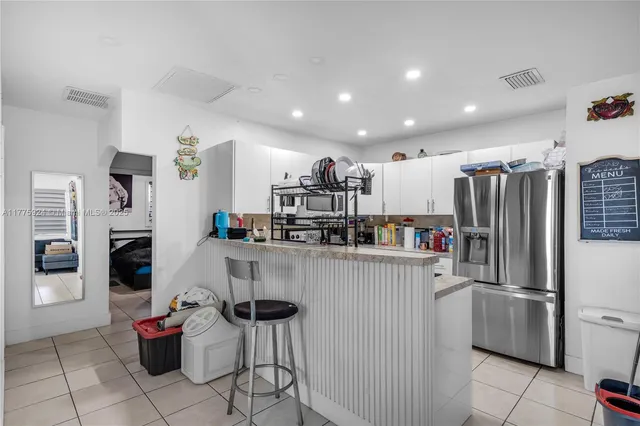 a kitchen with refrigerator and cabinets
