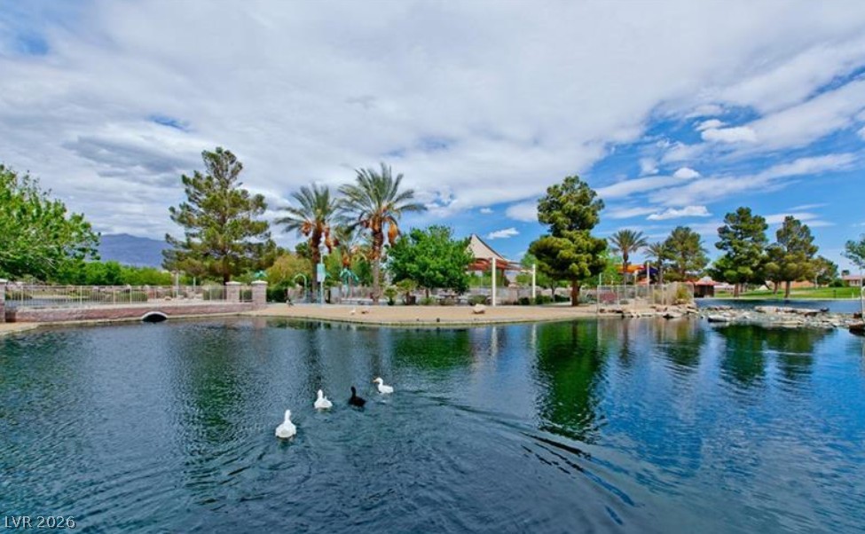 6405 North Raptor Court North Las Vegas, NV 89084 - Photo 63 of 66 Lush landscaping surrounds a tranquil lake, offering a serene community ambiance.