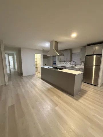 a large kitchen with stainless steel appliances granite countertop a sink and refrigerator