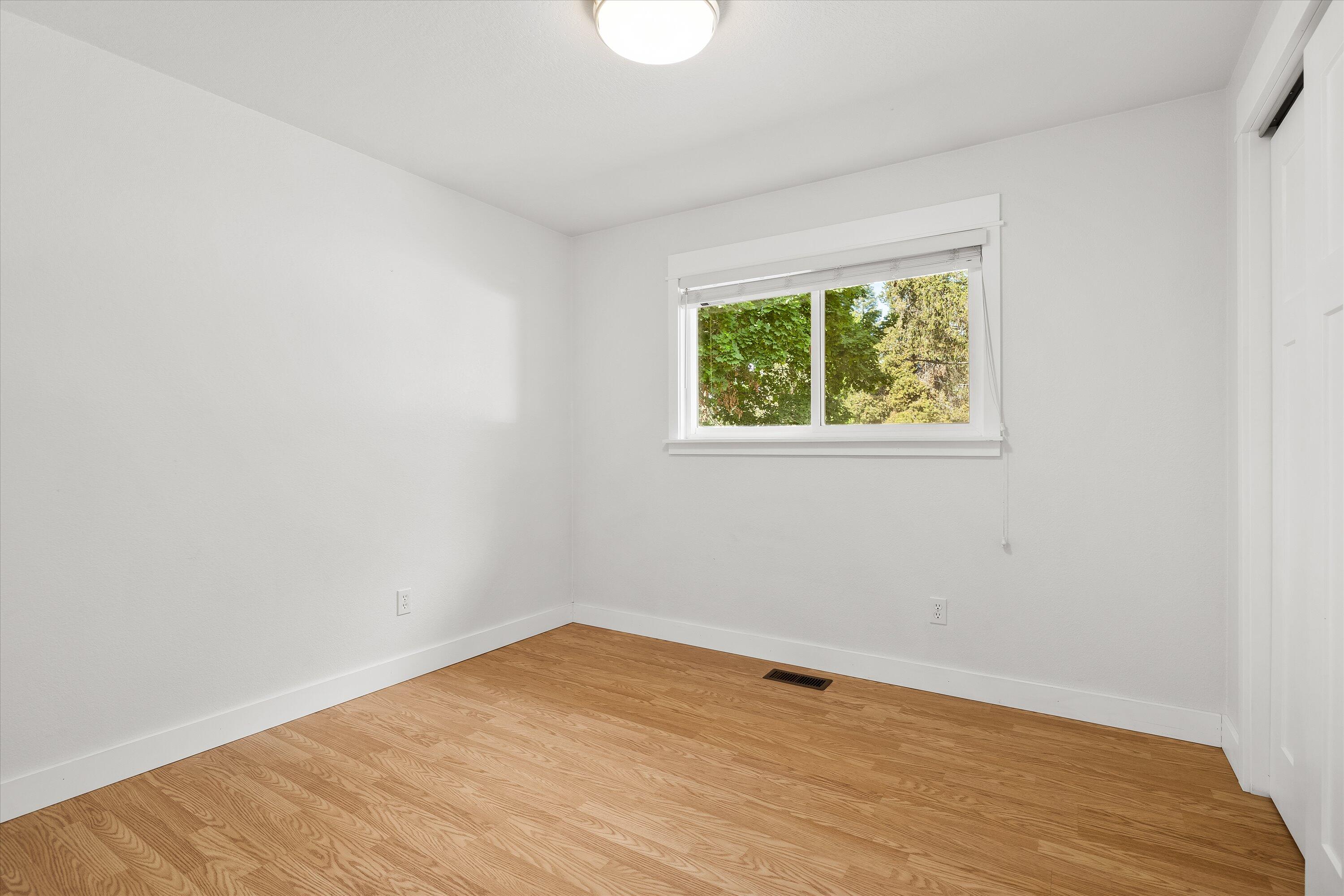 63634 Hunters Circle Bend, OR 97701 - Photo 13 of 28 an empty room with wooden floor and windows