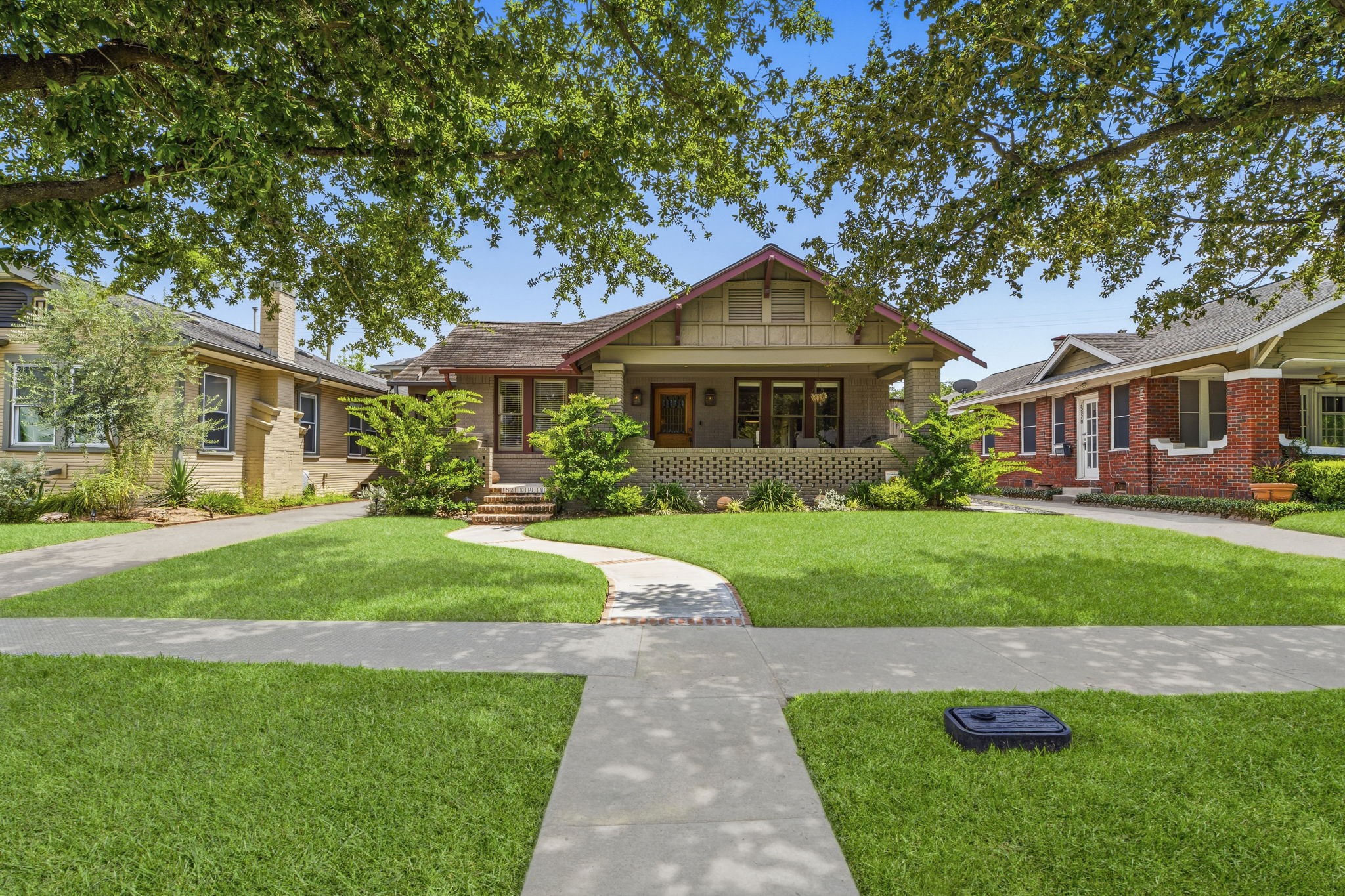 1521 Kipling Street Houston, TX 77006 - Photo 2 of 35 Charming single-story home with a welcoming front porch, surrounded by a well-maintained lawn and mature trees. It features a classic design with a mix of brick and wood accents, nestled in a friendly neighborhood.