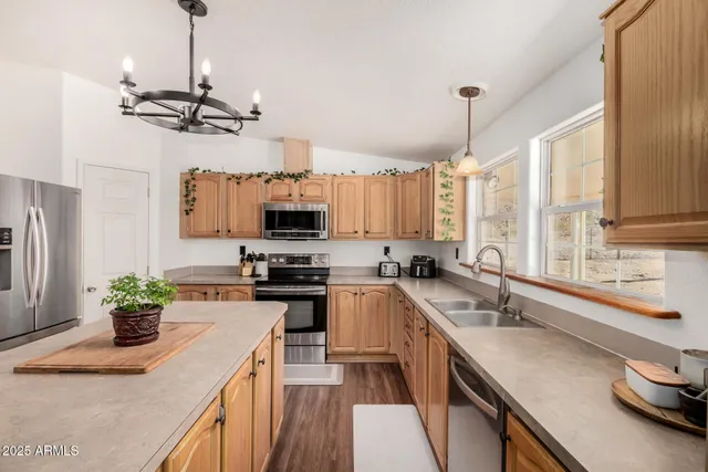 a kitchen with stainless steel appliances granite countertop a sink a stove top oven a counter space and cabinets