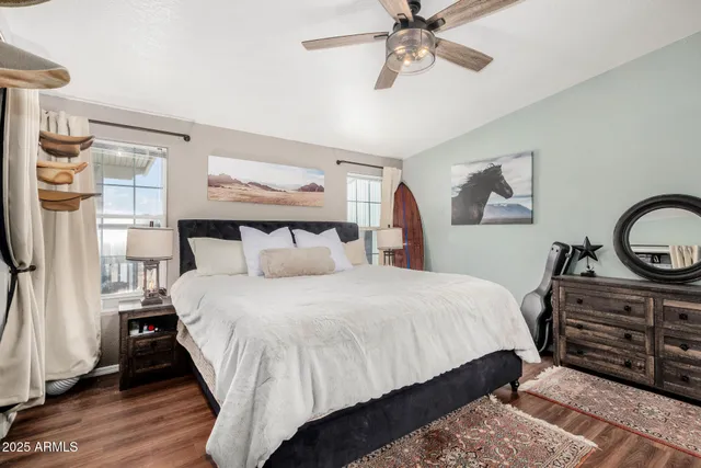 a bedroom with bed and paintings on the wall