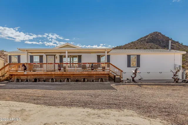 a view of a house with a large space and a car park in front of it