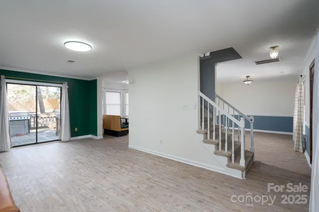 an empty room with windows and stairs