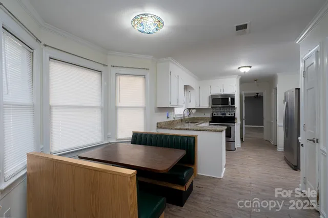 a kitchen with a refrigerator and a stove top oven