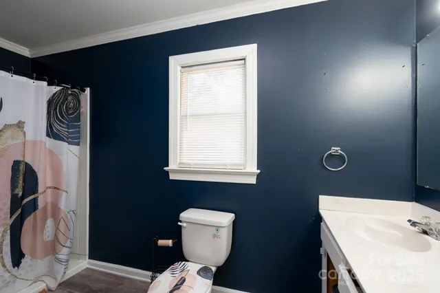 a bathroom with a toilet a sink and mirror