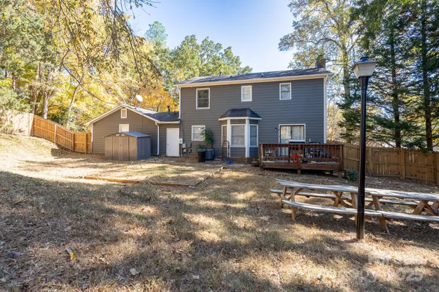 a front view of a house with a yard covered with snow and trees