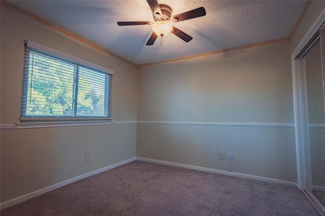 an empty room with a window and a fan