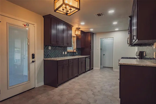 a large kitchen with stainless steel appliances granite countertop a stove a sink dishwasher and a refrigerator