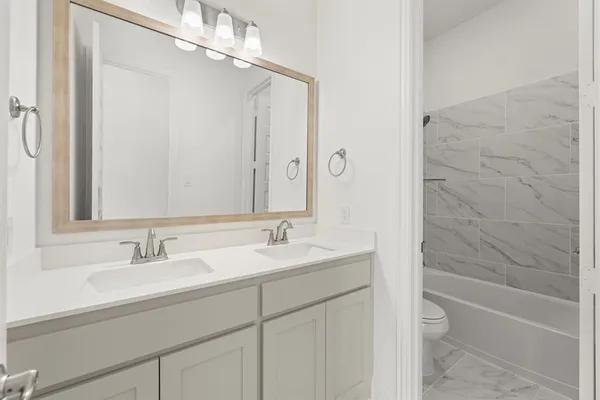 a bathroom with a granite countertop sink a toilet and shower