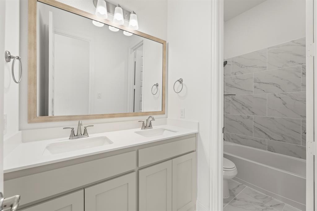 2006 Wickersham Road Rockwall, TX 75087 - Photo 23 of 33 a bathroom with a granite countertop sink a toilet and shower