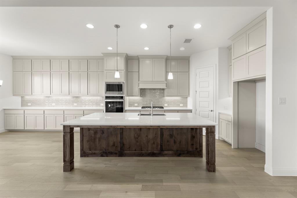 2006 Wickersham Road Rockwall, TX 75087 - Photo 9 of 33 a large kitchen with kitchen island a sink stainless steel appliances and cabinets