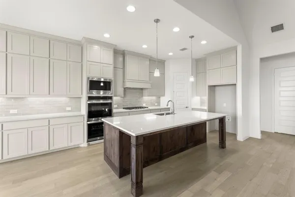 a kitchen with a sink stove and refrigerator