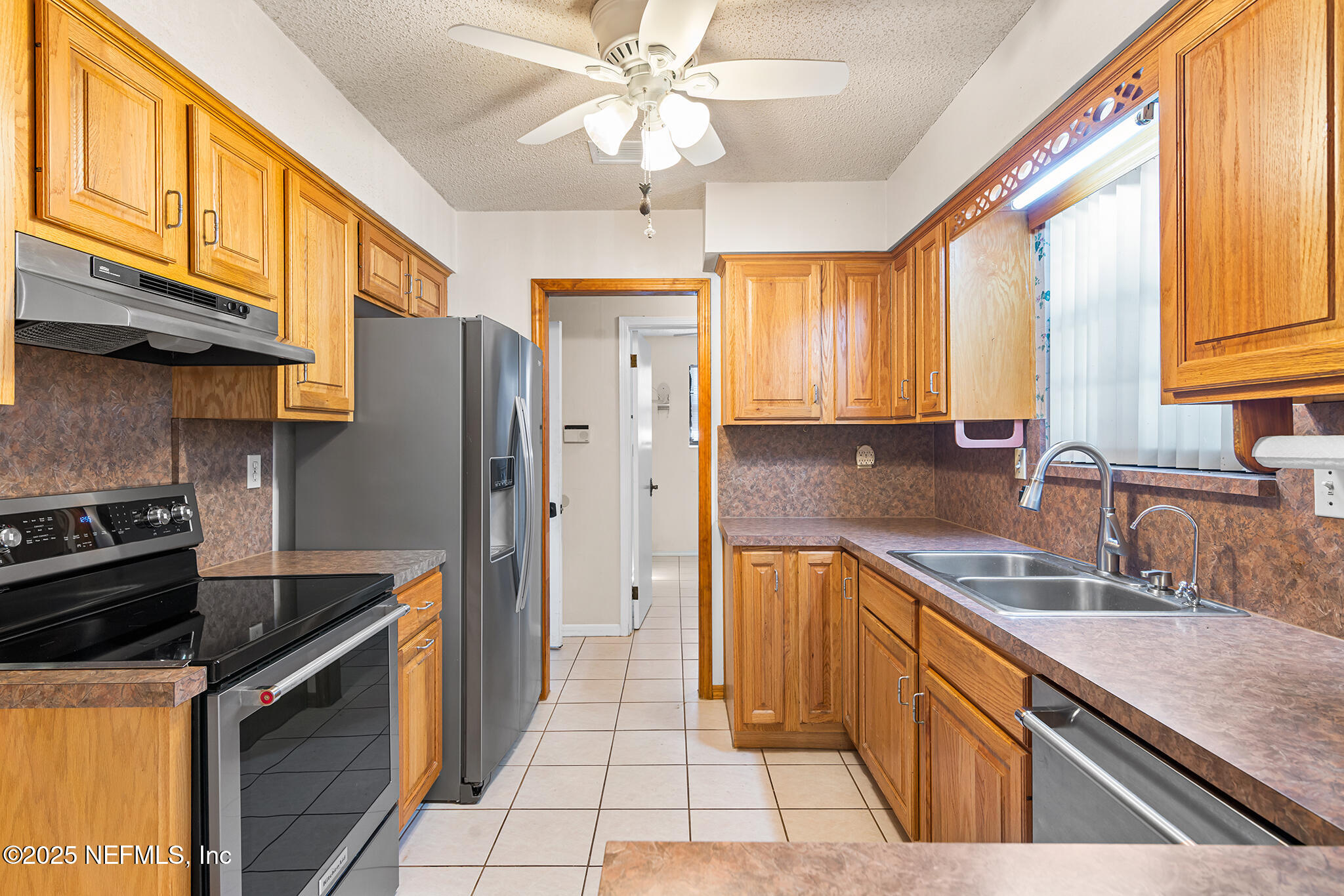 12850 Deep Lagoon Place West Jacksonville, FL 32246 - Photo 22 of 51 a kitchen with stainless steel appliances granite countertop a sink a stove and a refrigerator