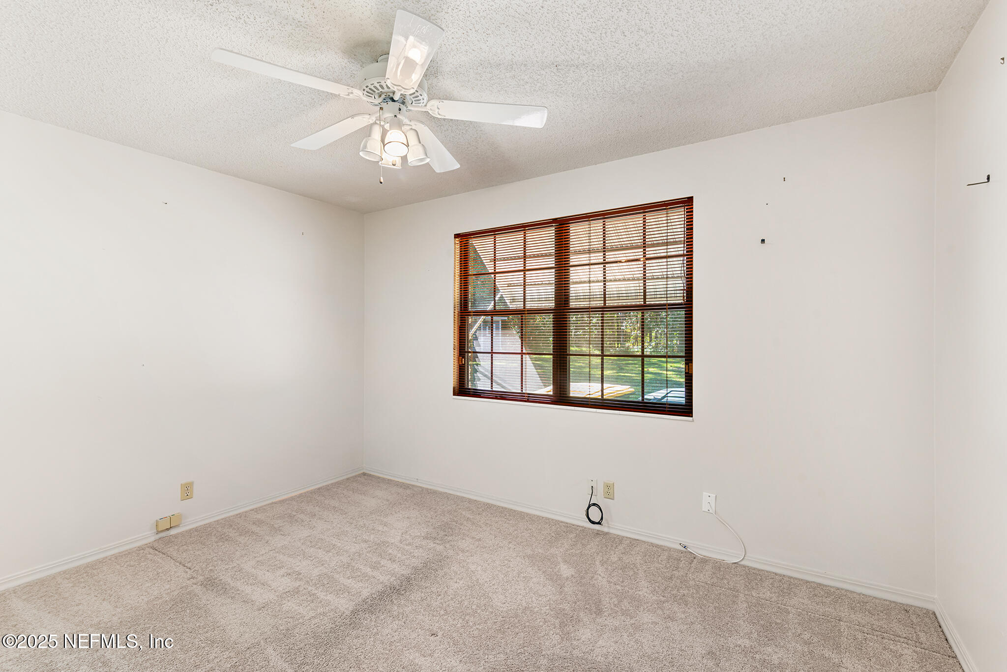 12850 Deep Lagoon Place West Jacksonville, FL 32246 - Photo 24 of 51 an empty room with a chandelier fan and windows