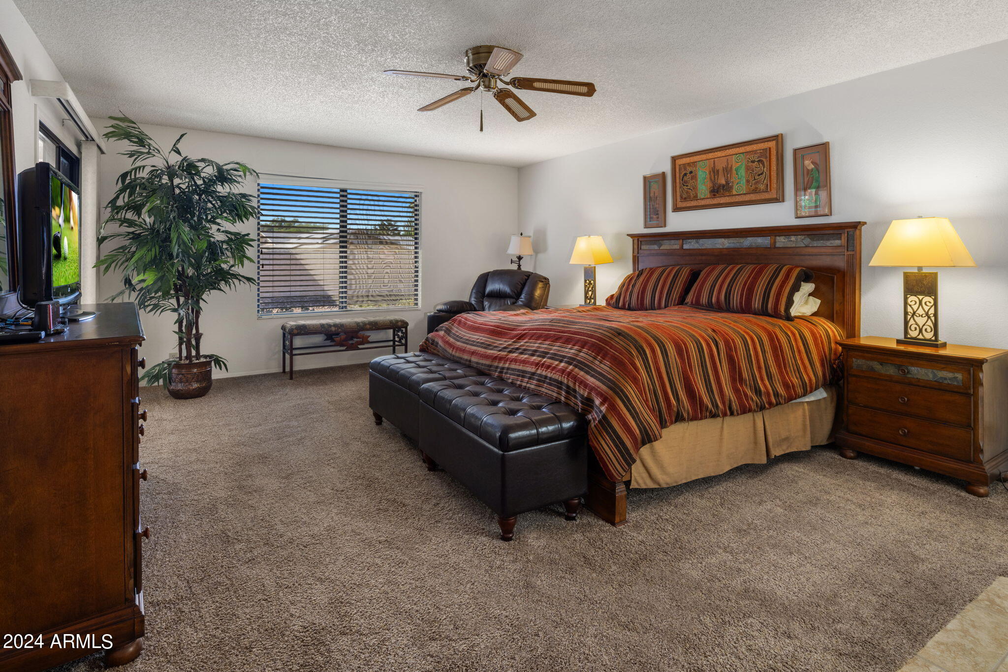 9856 West Rimrock Drive Peoria, AZ 85382 - Photo 26 of 37 a spacious bedroom with a bed lamp and a chandelier