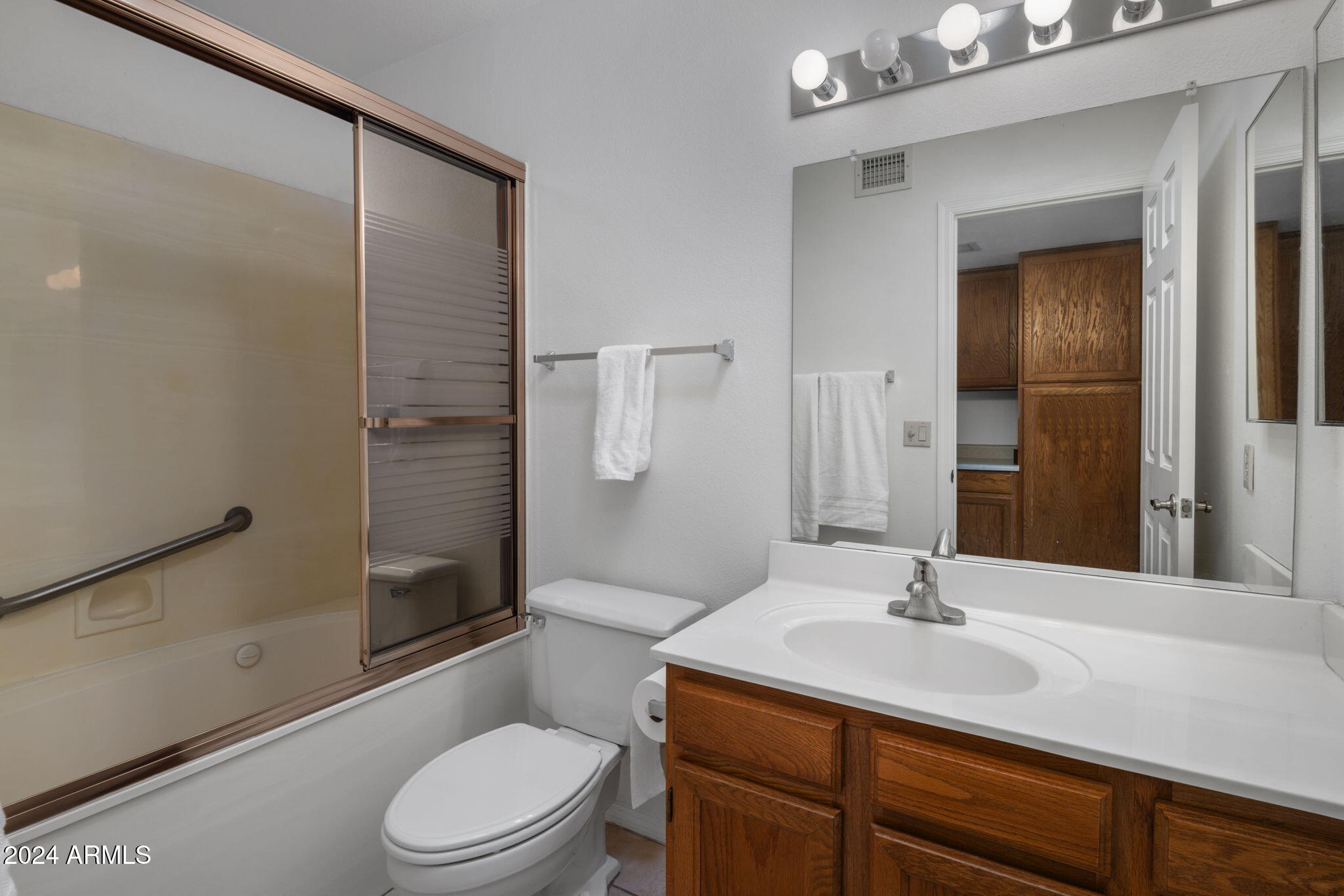 9856 West Rimrock Drive Peoria, AZ 85382 - Photo 32 of 37 a bathroom with a sink toilet vanity and shower