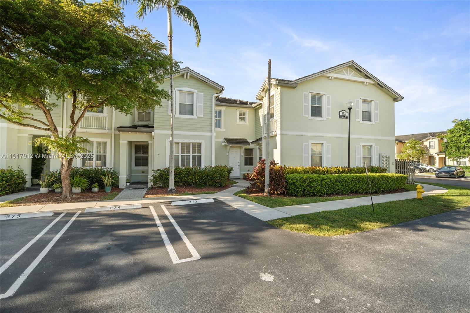 a view of a large white house with a yard next to a road