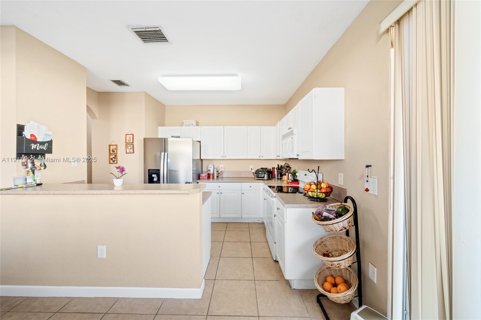 152 Southeast 29th Avenue, Unit 9 Homestead, FL 33033 - Photo 8 of 26 a kitchen with a refrigerator and white cabinets