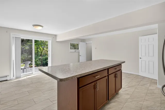 a kitchen with kitchen island a sink a counter top space and living room view