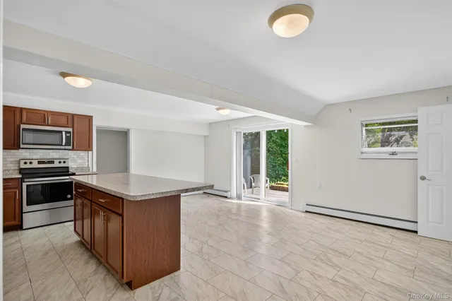 a kitchen with stainless steel appliances granite countertop a stove a sink and a refrigerator