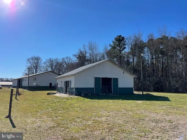 a front view of house with yard and trees in the background