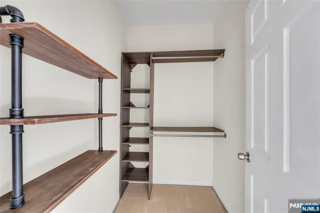 a view of walk in closet with empty racks