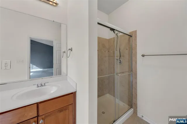 a bathroom with a shower sink and mirror