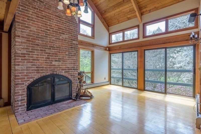 20 Lawton Road Leverett, MA 01054 - Photo 16 of 39 a living room with a fireplace and floor to ceiling windows