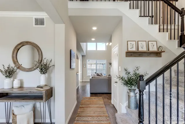 a view of a hallway with a livingroom and a kitchen