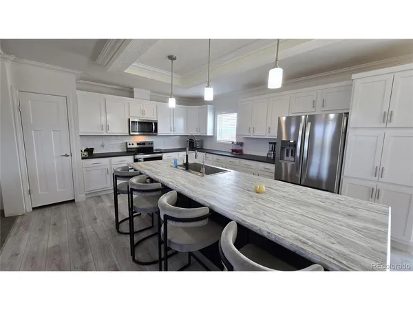 a kitchen with kitchen island a wooden floor and white appliances