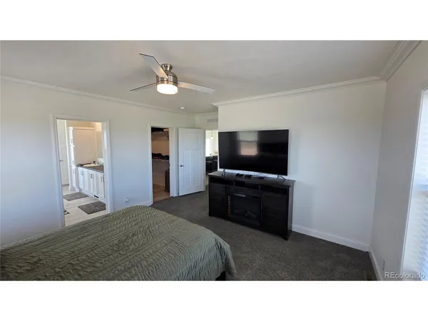 a living room with a flat screen tv and kitchen view