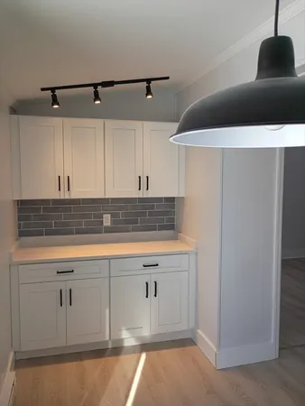 a kitchen with white cabinets and appliances
