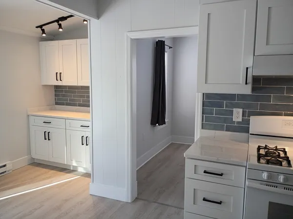 a kitchen with white cabinets and white appliances