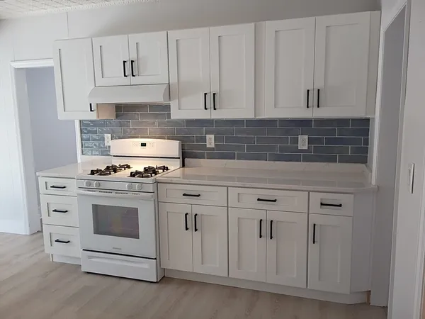 a kitchen with white cabinets and white appliances