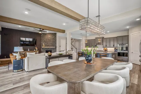 a kitchen with a dining table chairs stainless steel appliances and cabinets