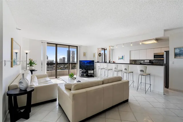 a living room with furniture and a view of kitchen