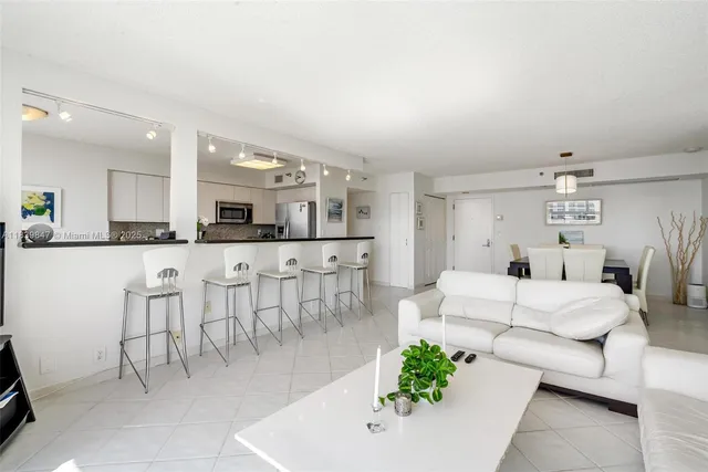 a large white kitchen with a white table and chairs