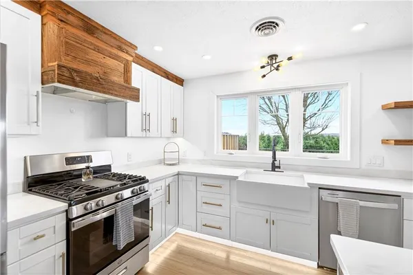 a kitchen with stainless steel appliances kitchen island a table and chairs in it