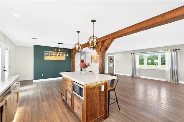 a kitchen with stainless steel appliances granite countertop a stove a sink dishwasher and a refrigerator with wooden floor