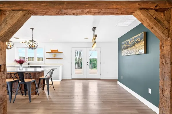 a open kitchen with a table chairs and a wooden floor