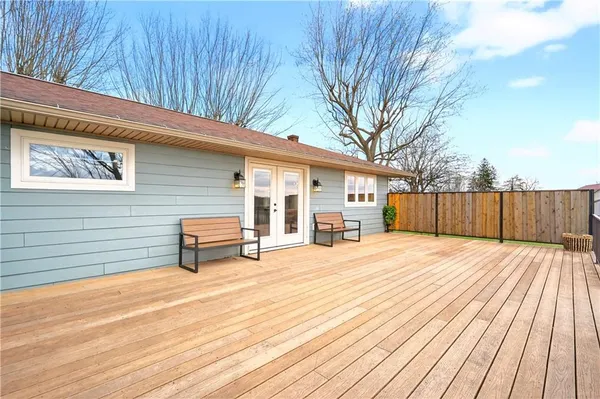 a view of an empty room with wooden floor and a kitchen