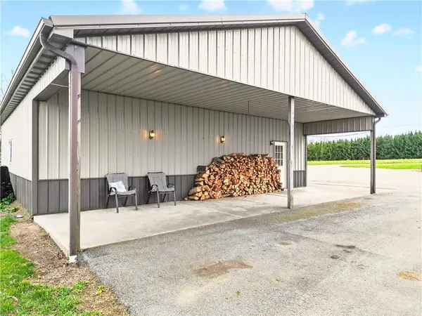 a front view of a house with a garden and trees