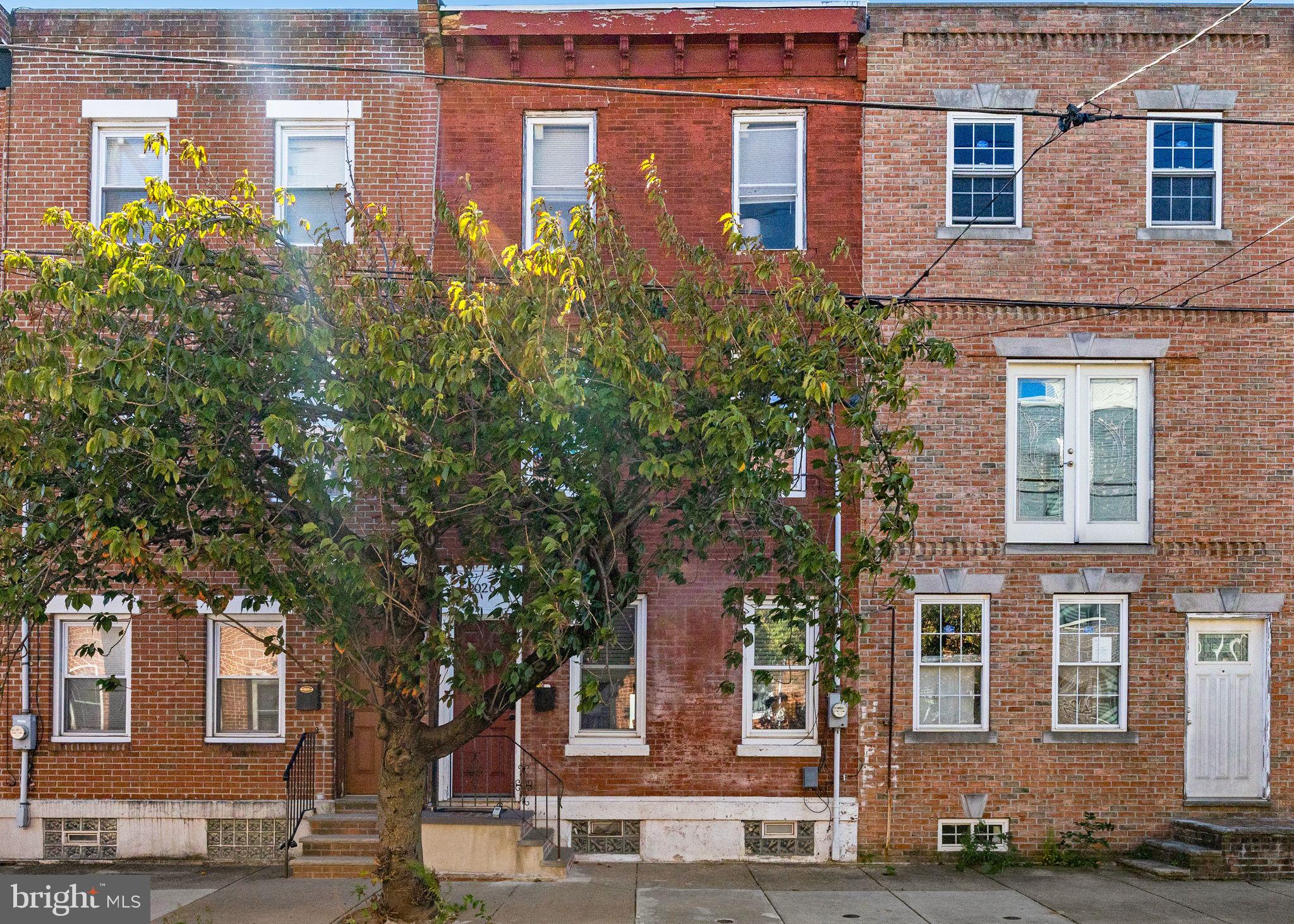 front view of a brick house next to a yard