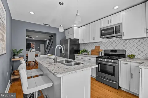 a kitchen with granite countertop a stove and a sink