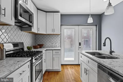 a kitchen with stainless steel appliances granite countertop a stove a sink and a microwave